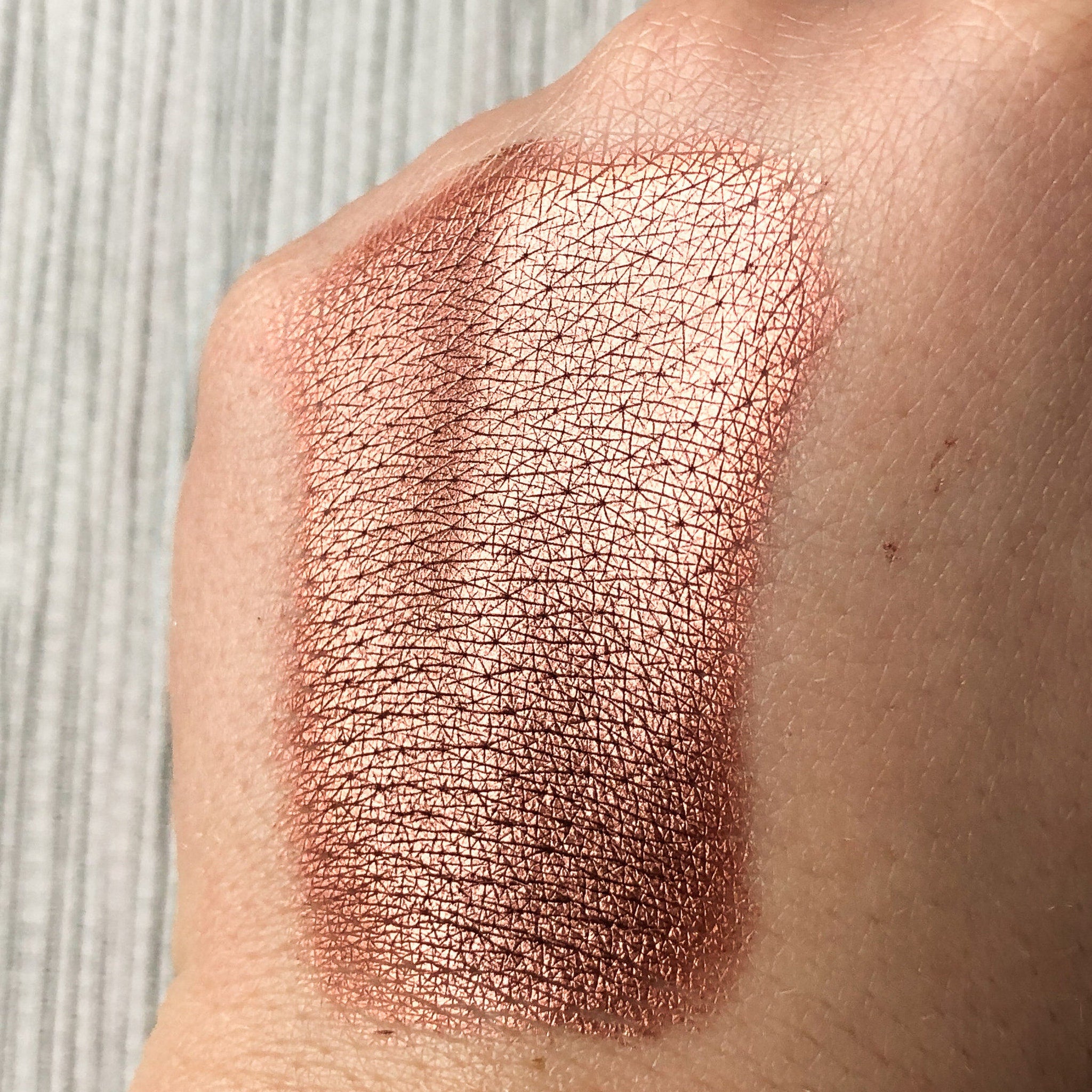 Hand applying Tala Gingerbread BR7 warm brown eye shadow pigment with fingertip for smooth blending