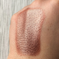 Hand applying Tala Gingerbread BR7 warm brown eye shadow pigment with fingertip for smooth blending