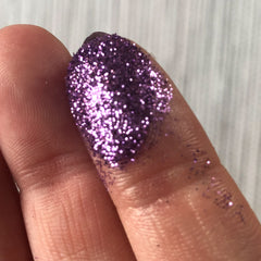 Purple glitter on finger, showing texture and light reflection, close-up view