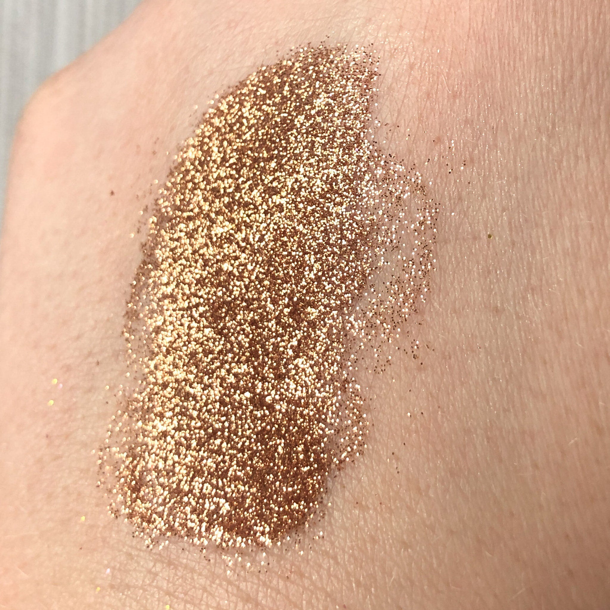 Close-up of Tala Cafe au Lait glitter eye shadow pigment showing shimmering beige particles in a small glass vial