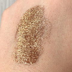 Close-up of Tala Cafe au Lait glitter eye shadow pigment showing shimmering beige particles in a small glass vial