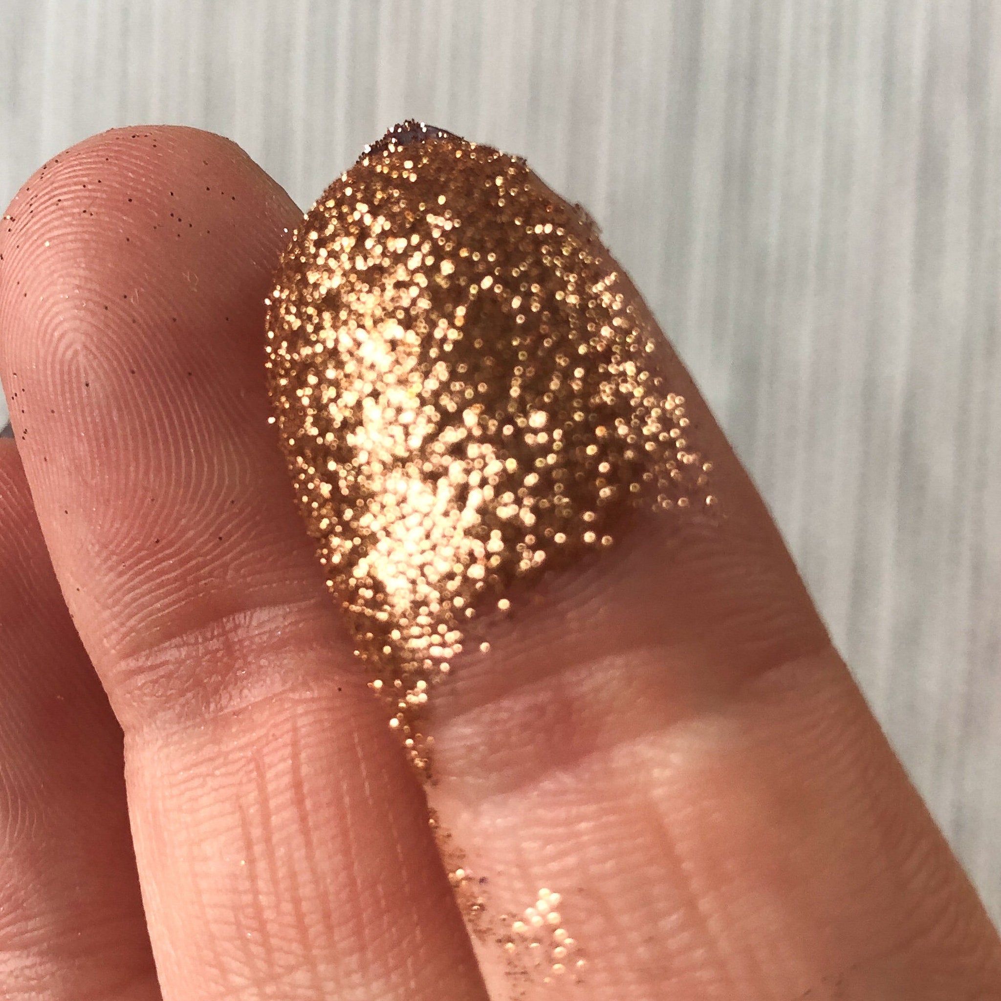 Tala Cafe au Lait Glitter Eye Shadow Pigment in sleek black tube with gold cap, displayed upright on marble surface