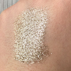 Close-up of Tala Golden Halo glitter eye shadow pigment showing intense metallic gold shimmer in textured finish