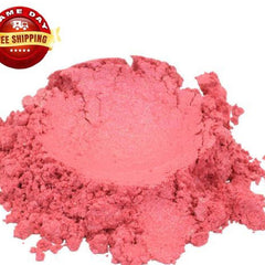 Close-up of shimmering raspberry pink cosmetic powder with red mica flecks in a round plastic jar