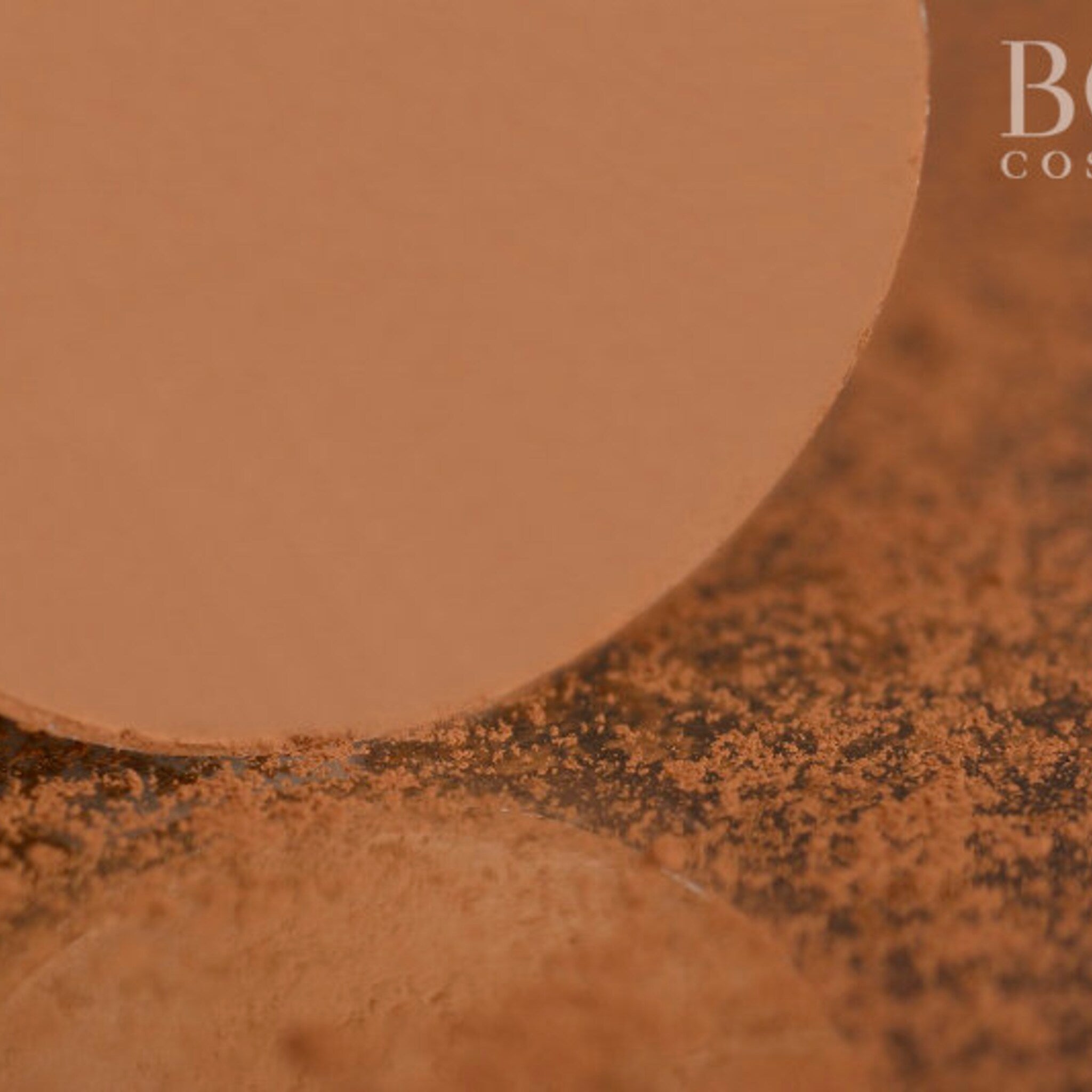 Side view of golden brown matte eyeshadow pan showing pressed powder texture and circular shape