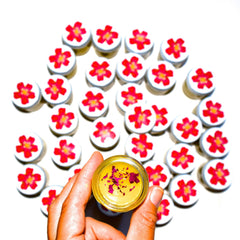 Side view of Beach Rose Beauty Balm in a sleek white jar with gold lid, showcasing its rich pink cream texture