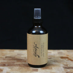 Spray bottle, brown glass bottle with clear plastic spray top, Astrielle label on wood surface