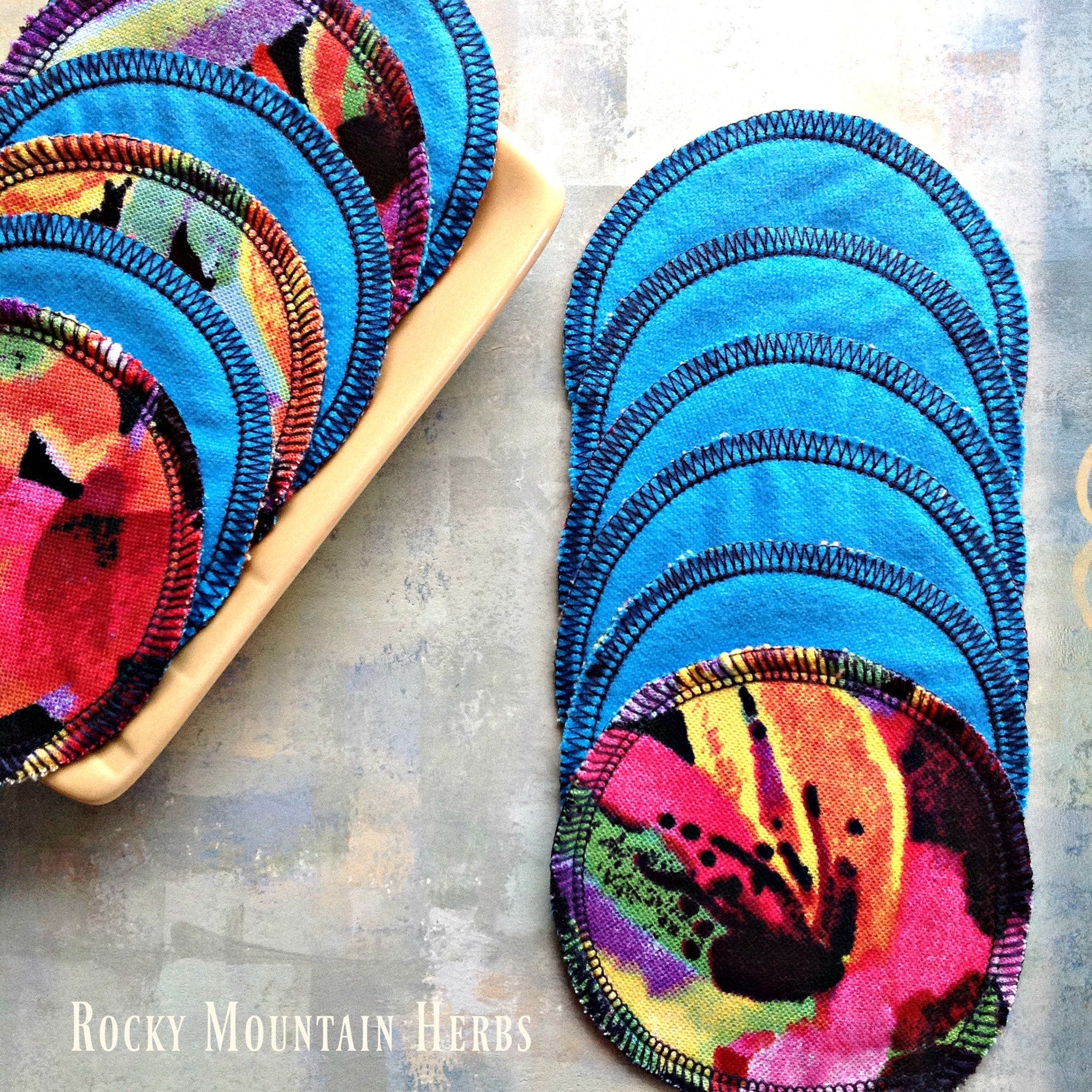 Reusable facial rounds, blue fabric with black stitching and colorful floral pattern, Rocky Mountain Herbs brand