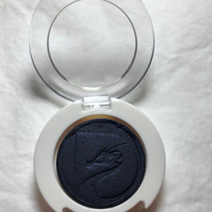 Side view of round 26mm pressed mineral eyeshadow by Jack showing smooth texture and rich pigment in compact