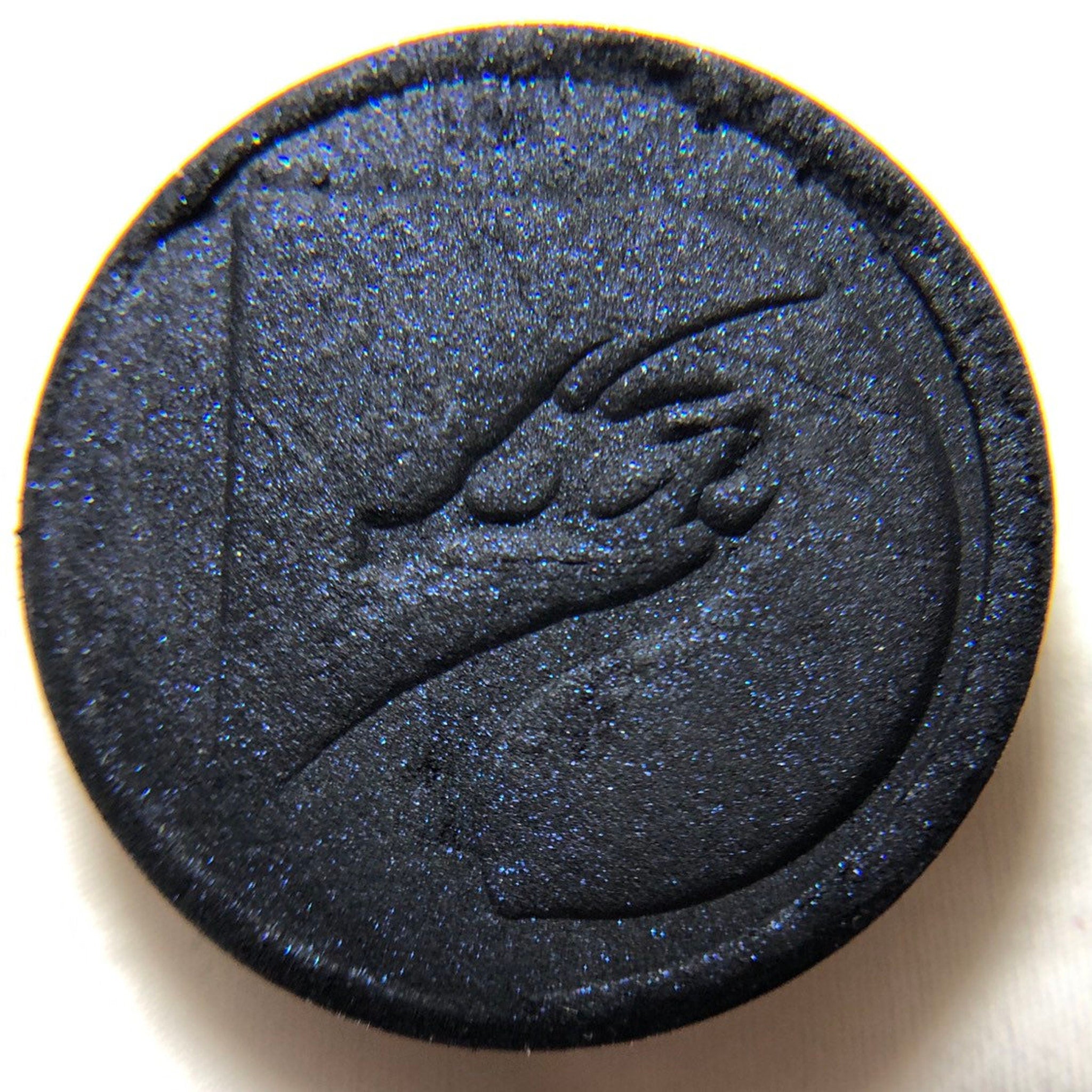 Close-up of pressed mineral eyeshadow pan showing smooth texture and rich pigmentation in a 26mm round compact