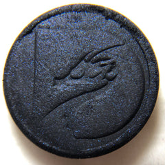 Close-up of pressed mineral eyeshadow pan showing smooth texture and rich pigmentation in a 26mm round compact