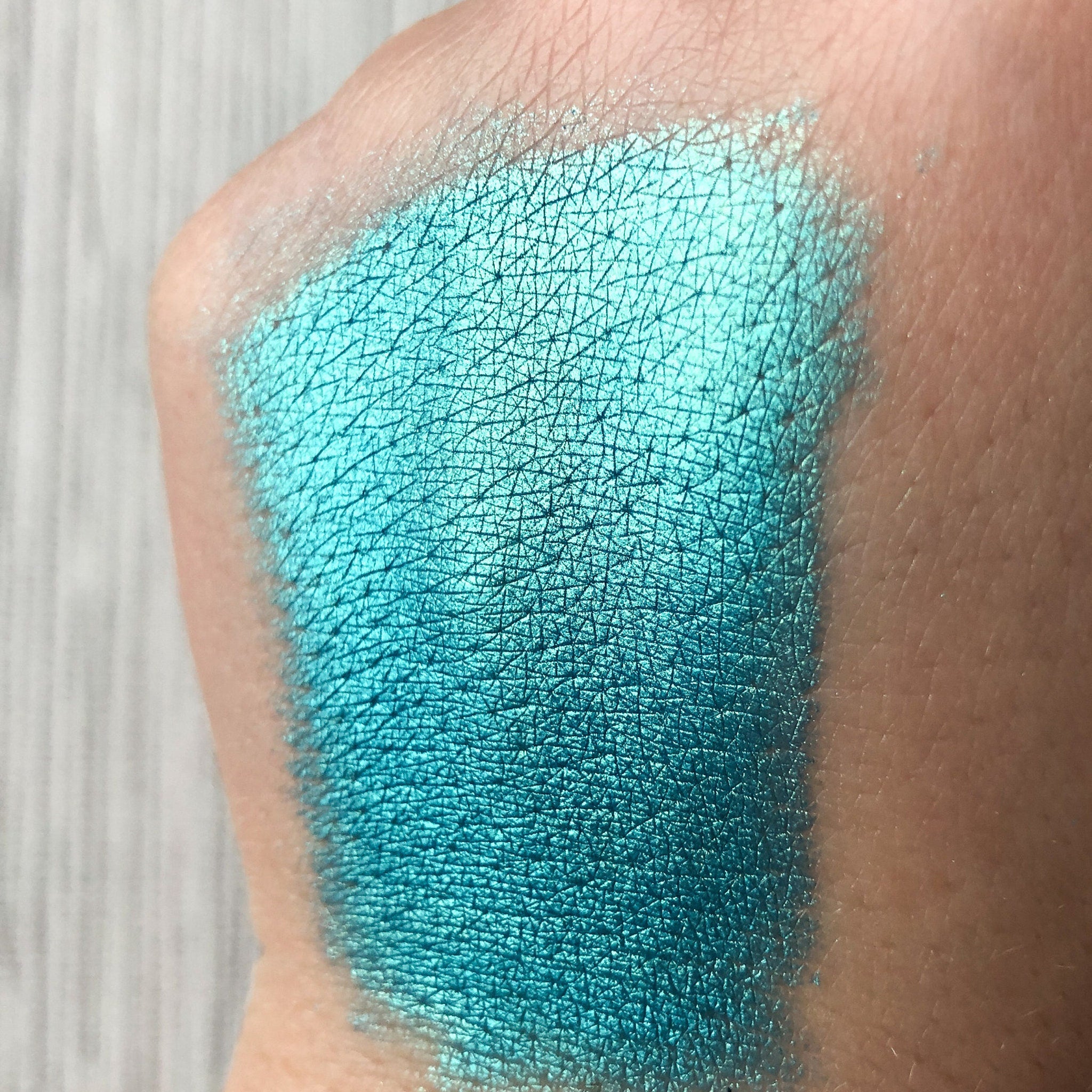 Close-up of Tala Lazure B6 Eye Shadow Pigment showing vibrant shimmery teal powder in small glass jar