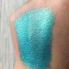Close-up of Tala Lazure B6 Eye Shadow Pigment showing vibrant shimmery teal powder in small glass jar