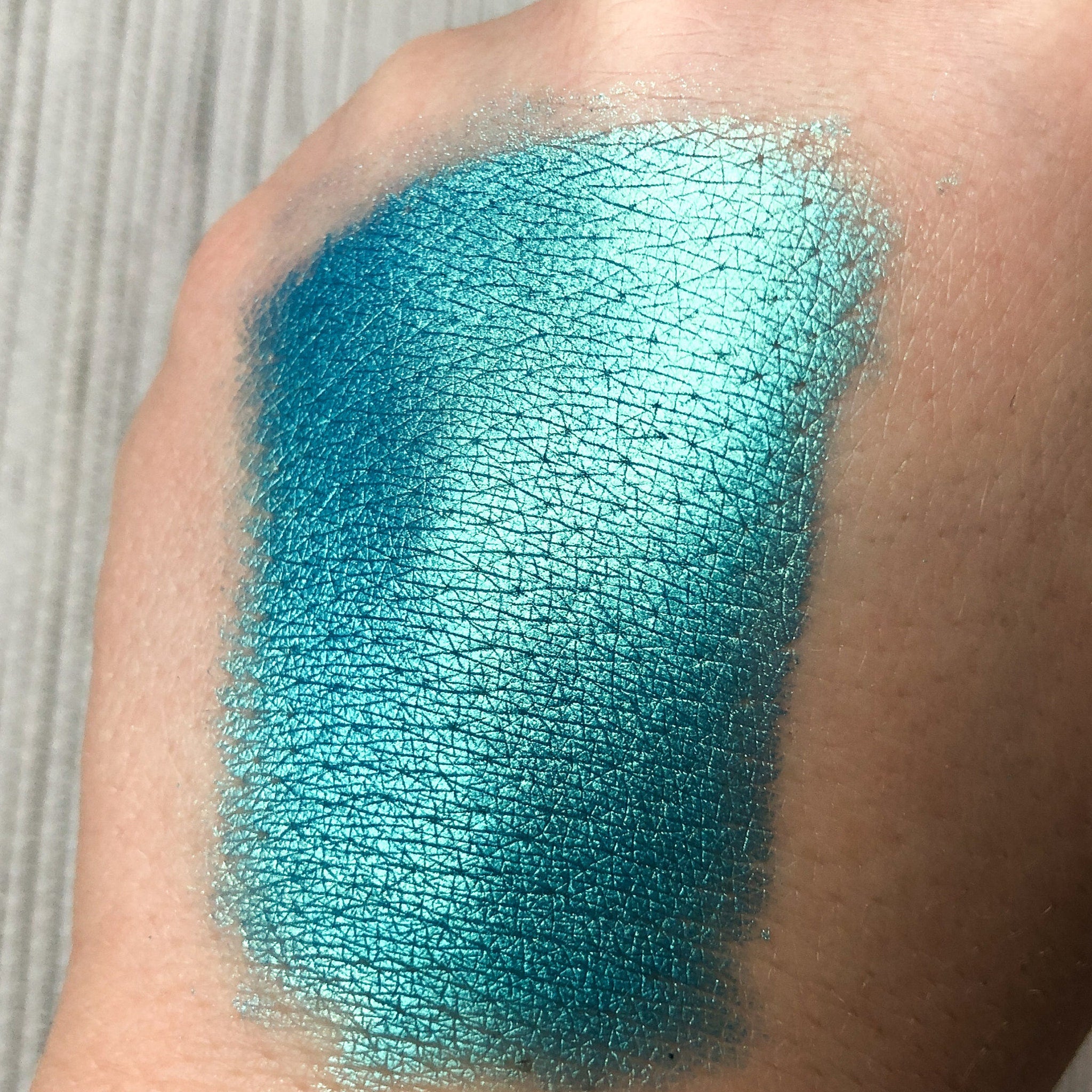 Side view of Tala Lazure B6 Eye Shadow Pigment in sleek 2ml tube with metallic blue cap and gradient color shift