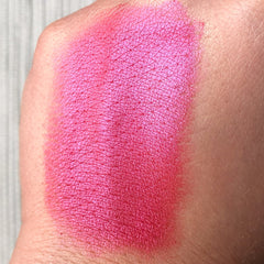 Hand applying rose wine shimmer eye shadow pigment to eyelid with fingertip