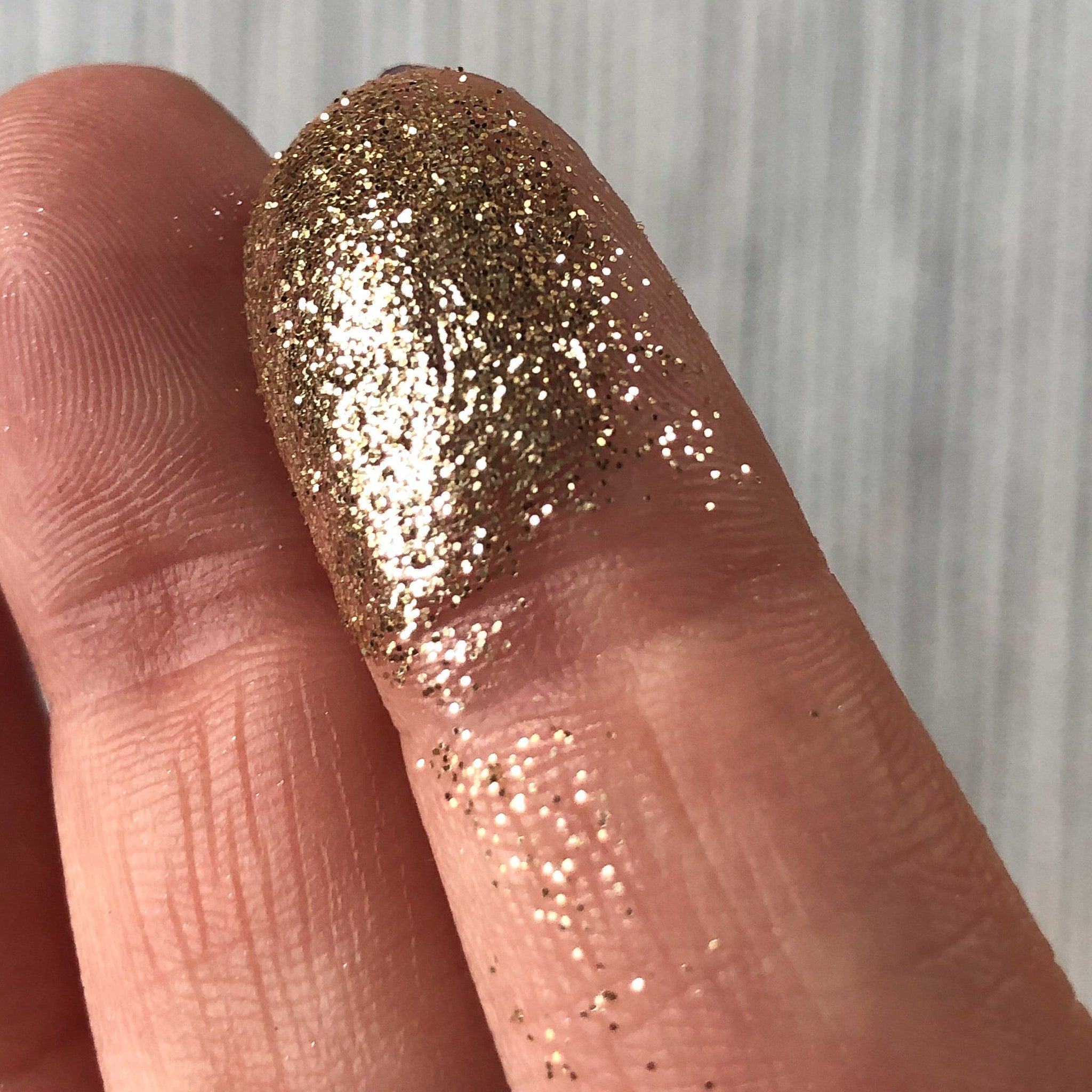 Tala Golden Halo Glitter Eye Shadow Pigment in sleek 2ml tube with gold cap, displayed on marble surface