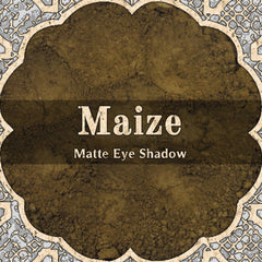Matte eyeshadow powder, dark gold color, with Maize brand text and decorative border