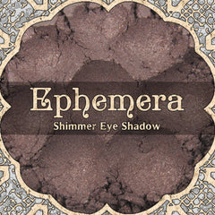 Close-up of EPHEMERA loose powder eyeshadow in shimmering cool mauve and chocolate brown, vegan formula in minimalist jar