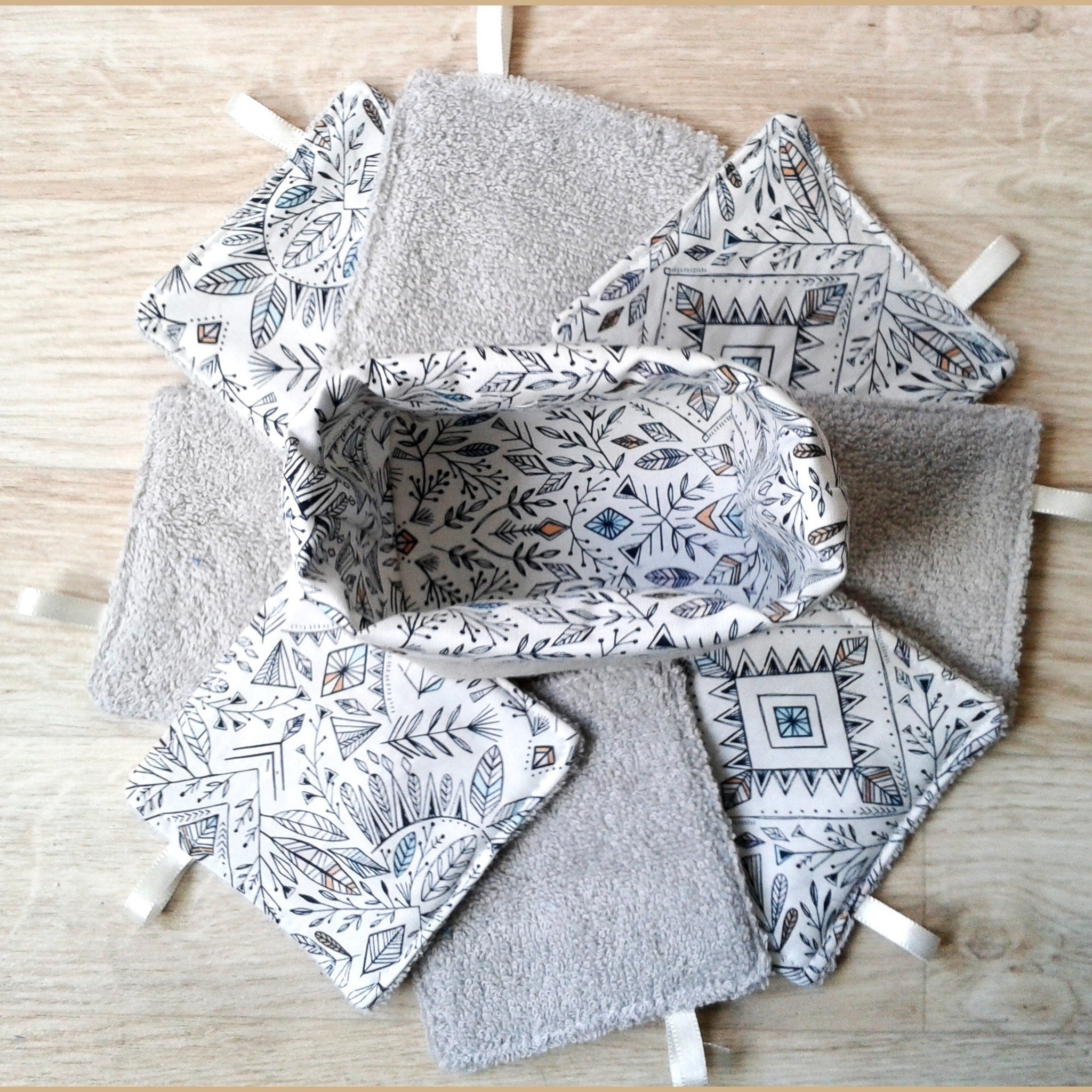 Washcloth set with gray terrycloth, white patterned fabric, and a small basket for storage.