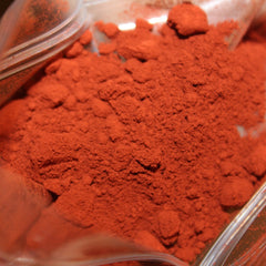 Hand applying shimmering mineral eye shadow with fingertip to eyelid, showcasing pigment blendability