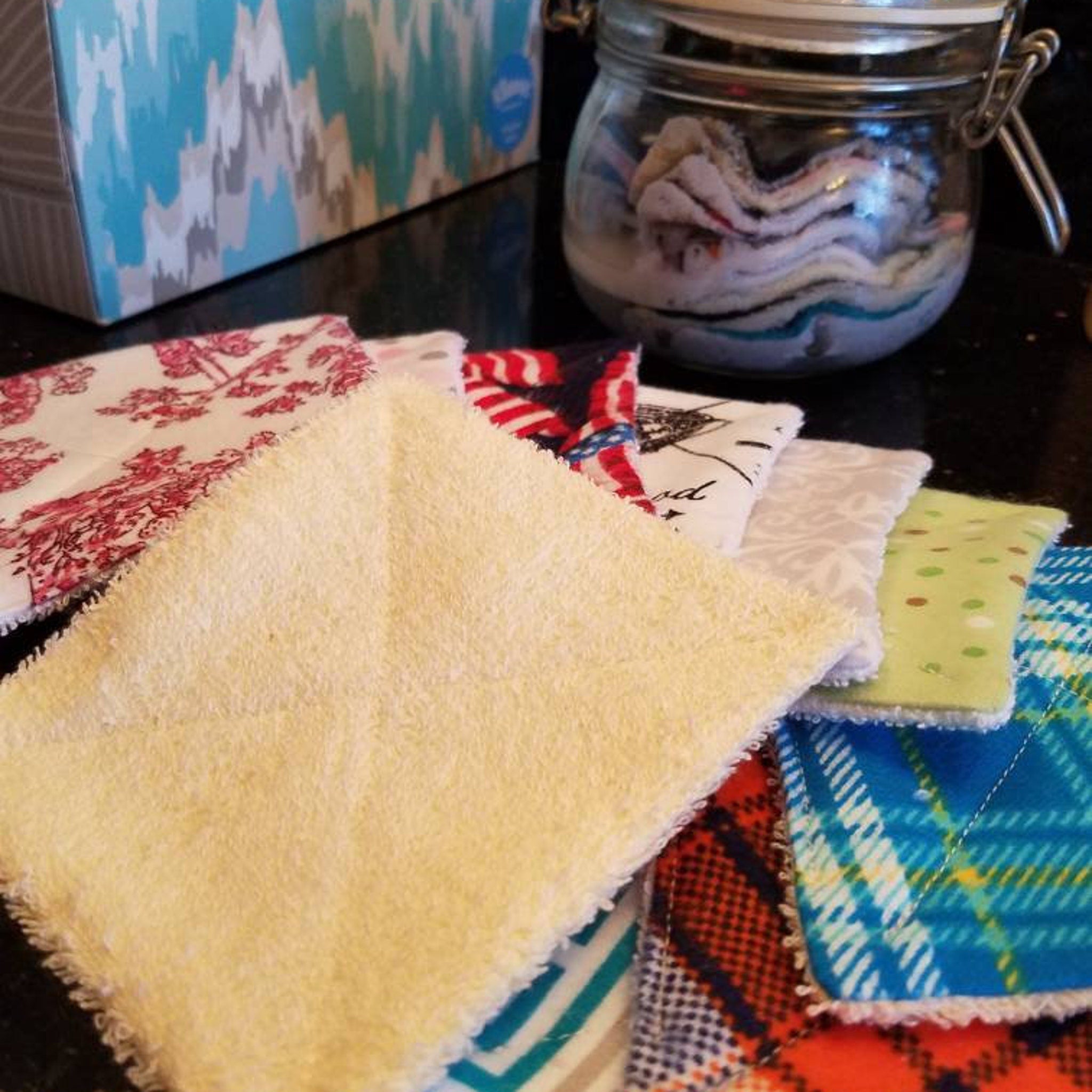 Reusable face cloths in yellow, red floral, and plaid patterns, assorted colors