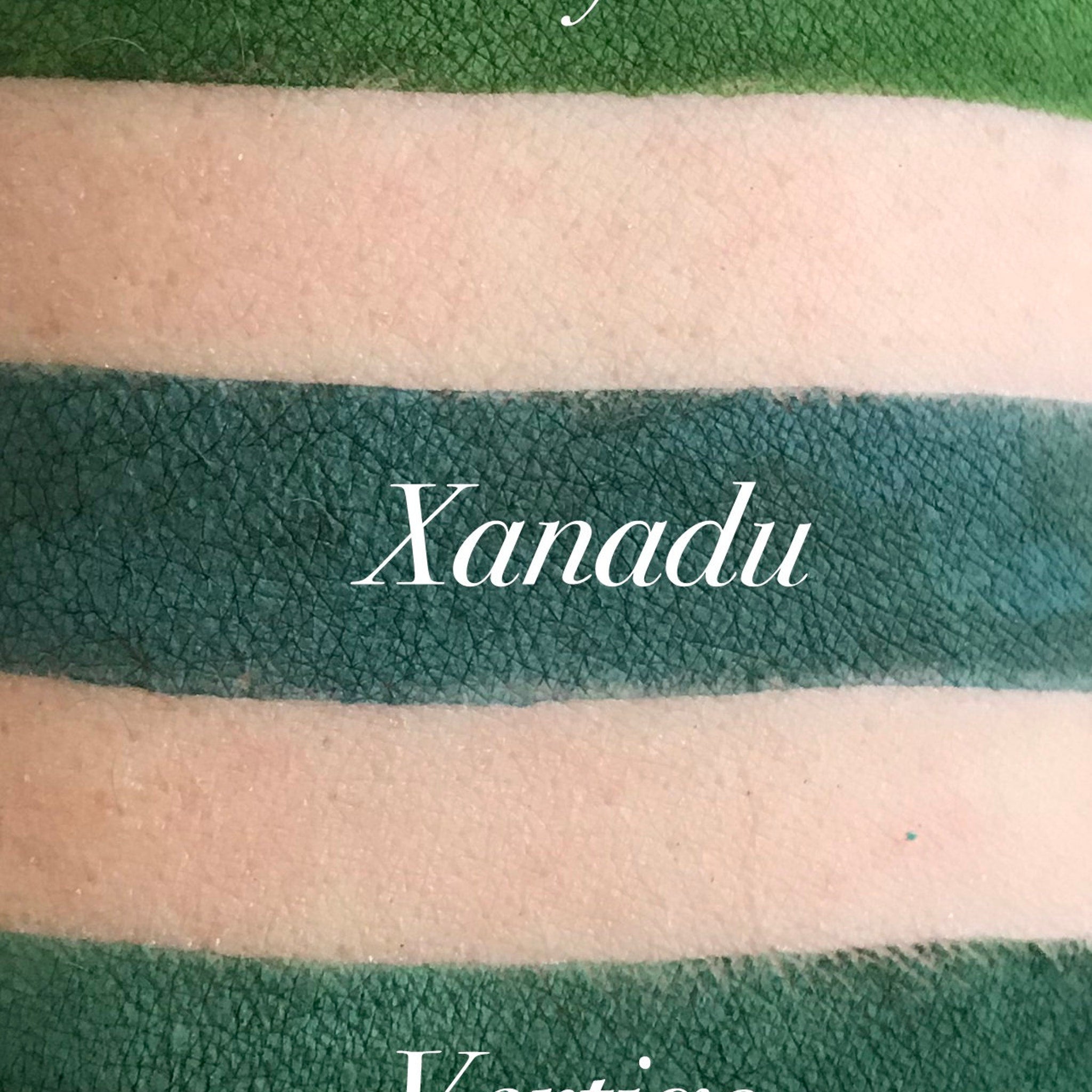 Close-up of matte green eyeshadow pan with smooth, velvety texture and rich pigment saturation