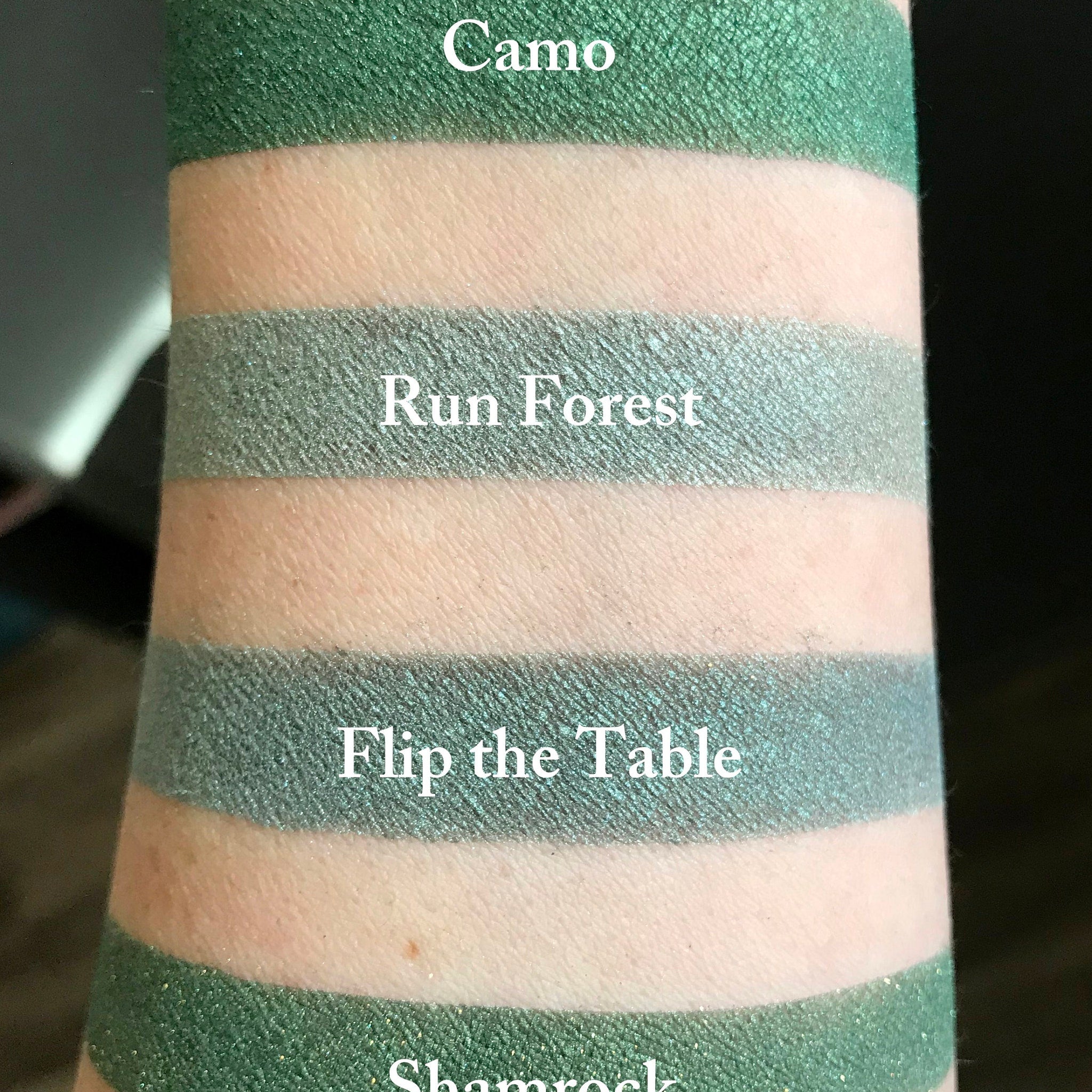 Close-up of matte CAMO green mineral eyeshadow with smooth powder texture in compact case