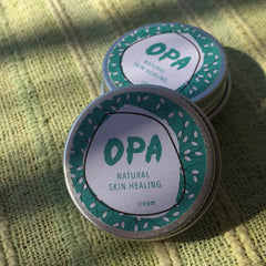 Cream jars with green and white label, metal tin, OPA brand text visible on white label