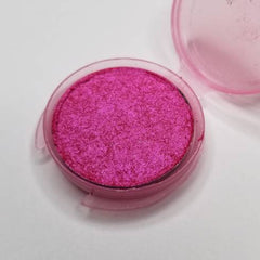 Close-up of vibrant bubblegum pink pressed eyeshadow with smooth matte finish in compact case