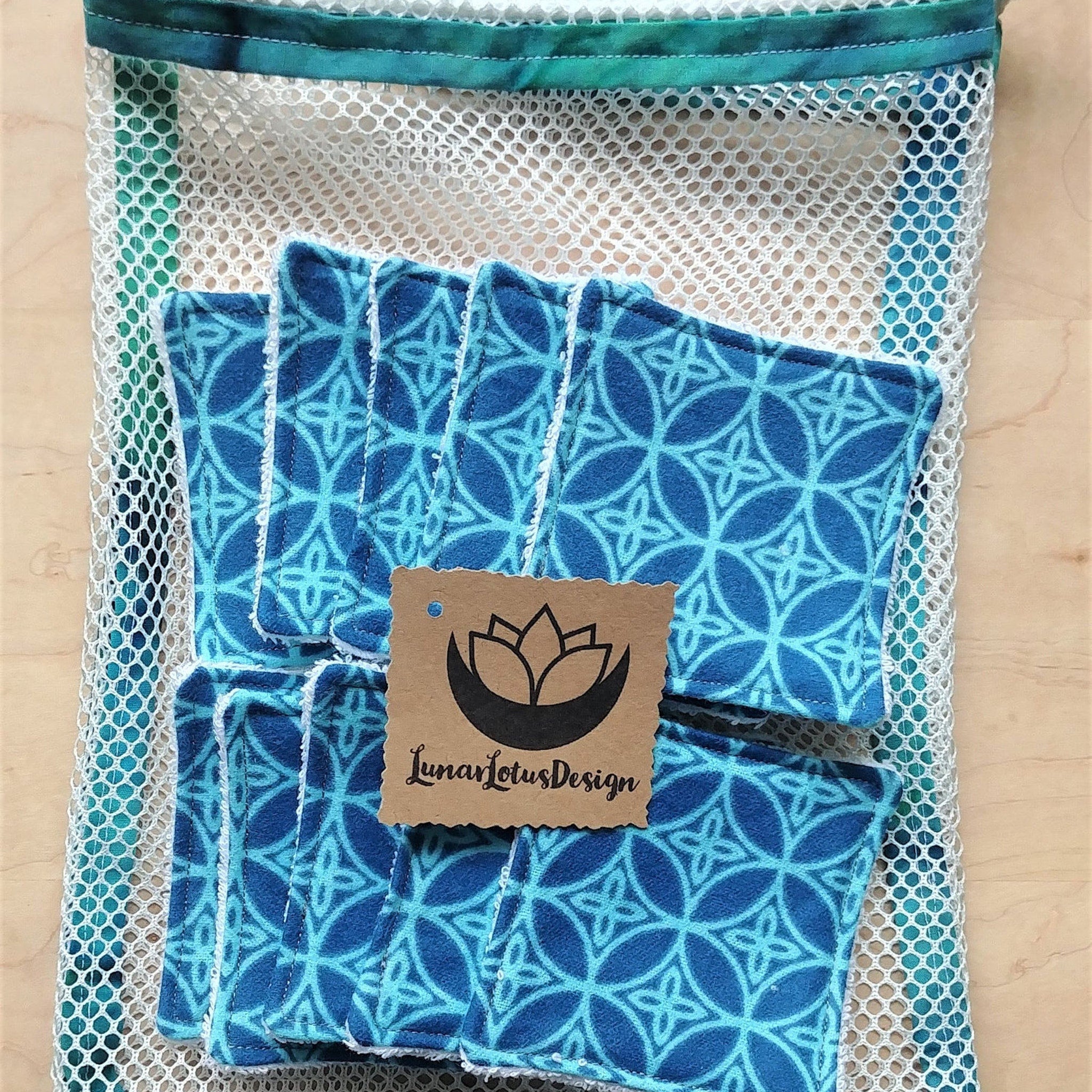Reusable face pads, blue patterned fabric, white trim, with mesh bag and Lunar Lotus Design tag