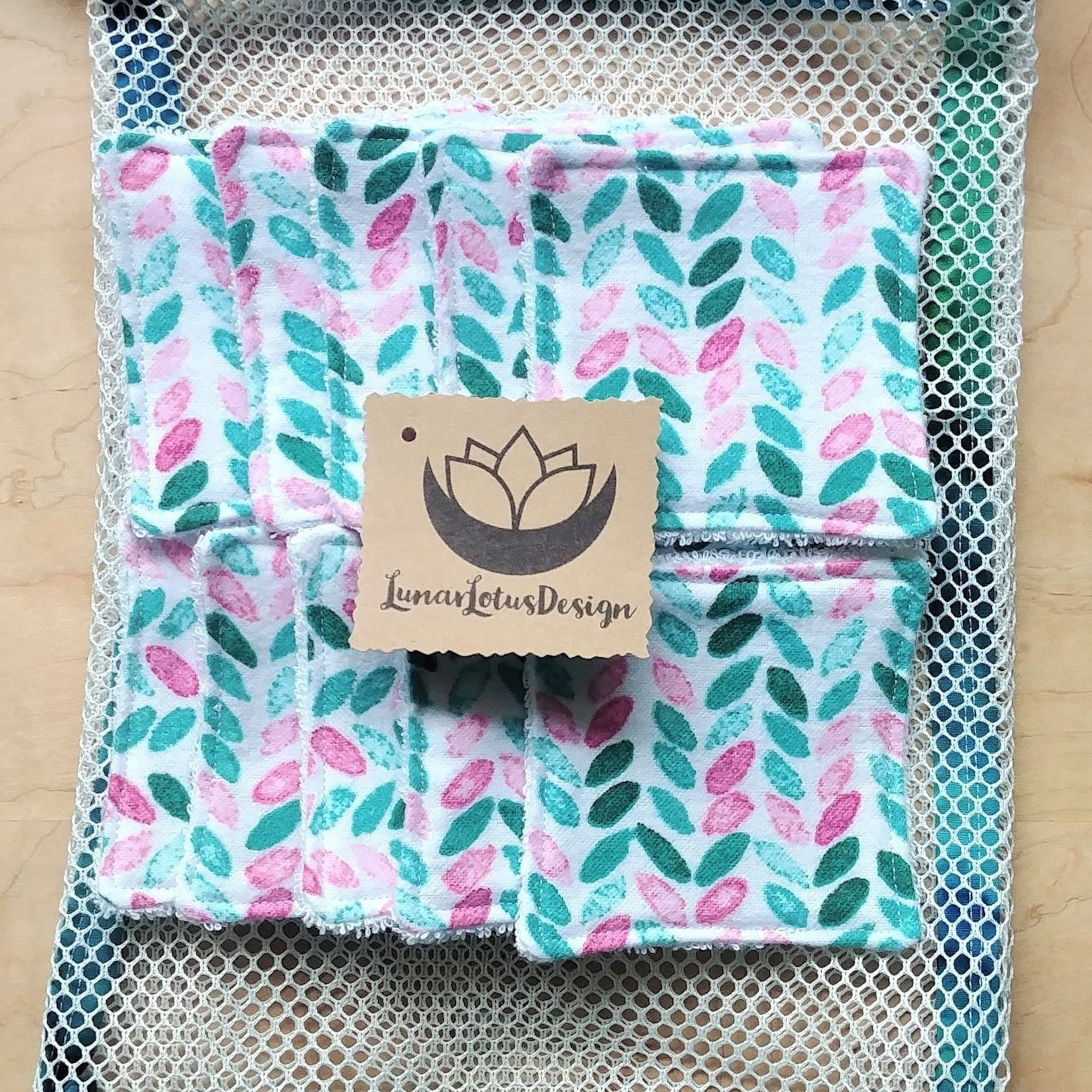 Reusable pads with leaf pattern, pink and teal leaves, white mesh bag, Lunar Lotus Design tag