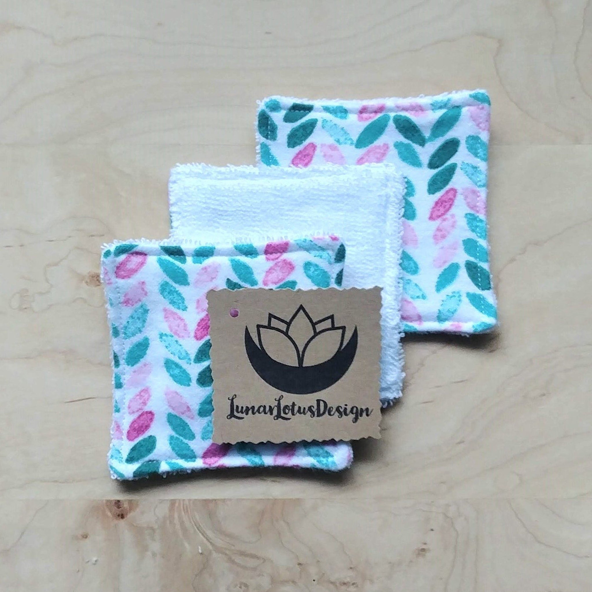 Reusable face cloths with leaf pattern in pink and teal, white terry cloth, Lunar Lotus Design tag