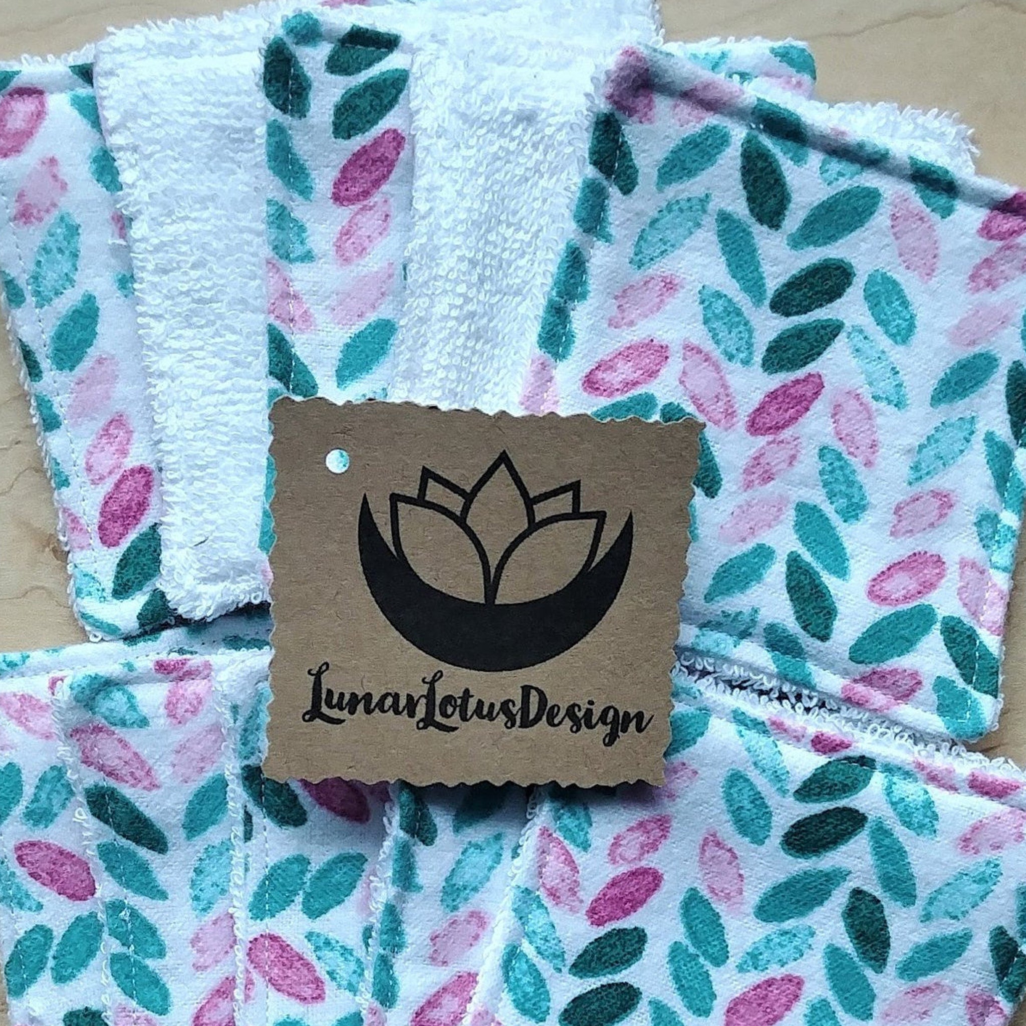 Reusable face cloths with white terry cloth, teal and pink leaf pattern, Lunar Lotus Design tag
