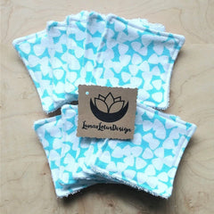 Reusable makeup remover pads, white and teal heart pattern, LunarLotusDesign tag on wooden surface