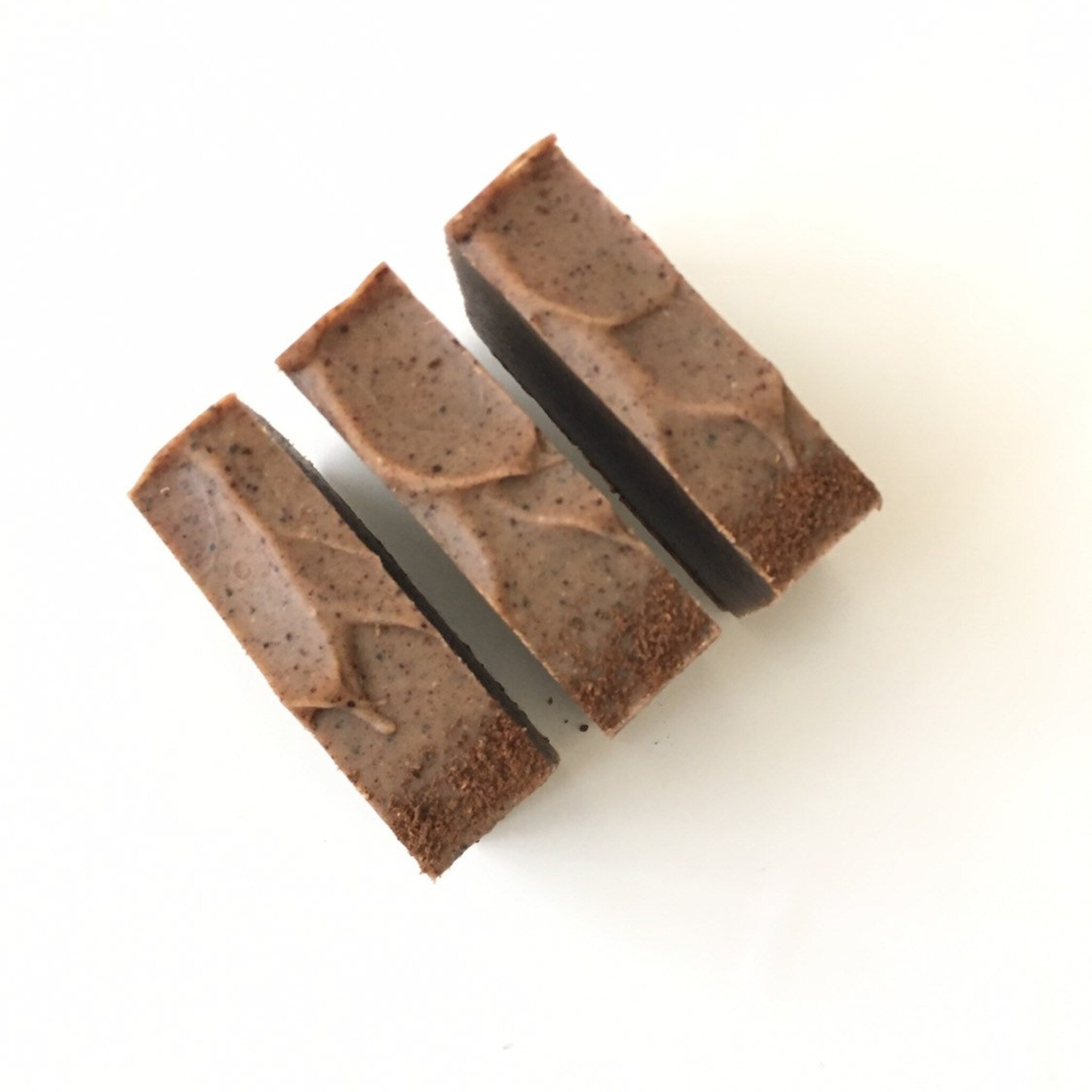 Soap bars brown with textured surface and dark edges, arranged on white background