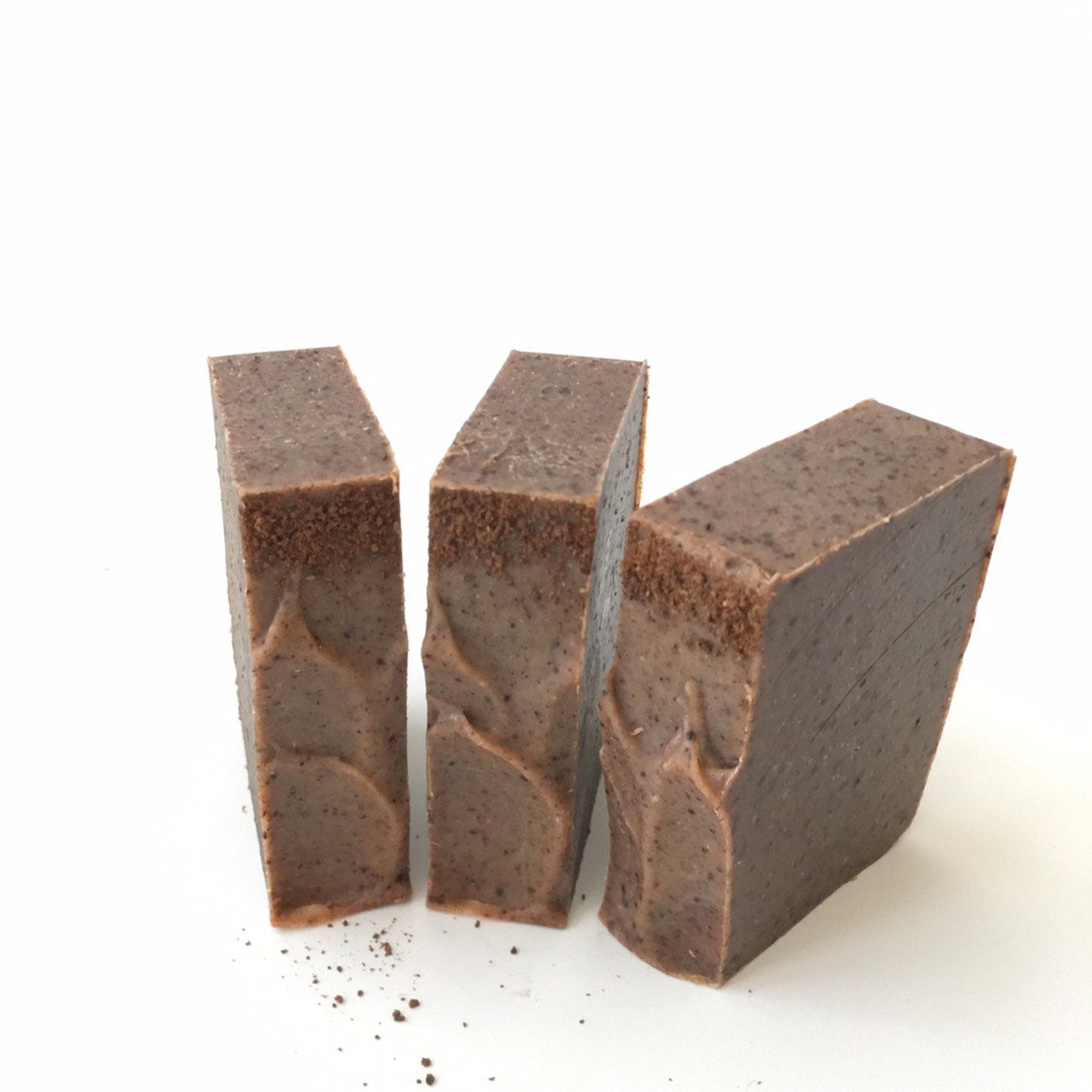 Soap bars, brown textured soap with visible grains and wavy pattern on white surface