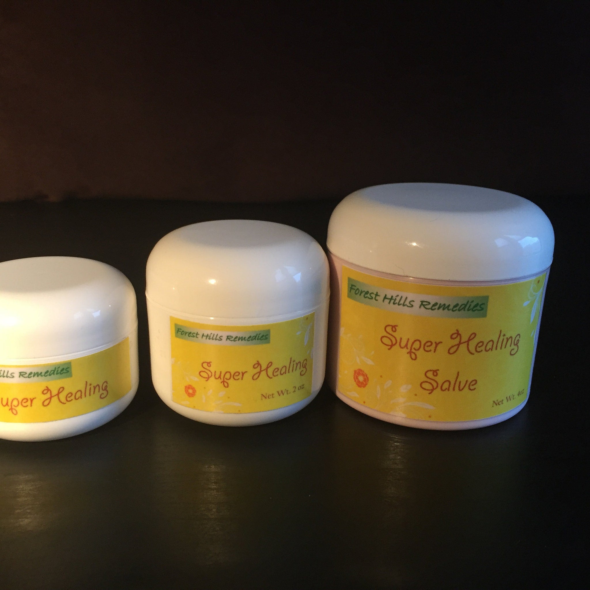 Salves in white jars with yellow labels, "Super Healing" text, and "Forest Hills Remedies" brand name