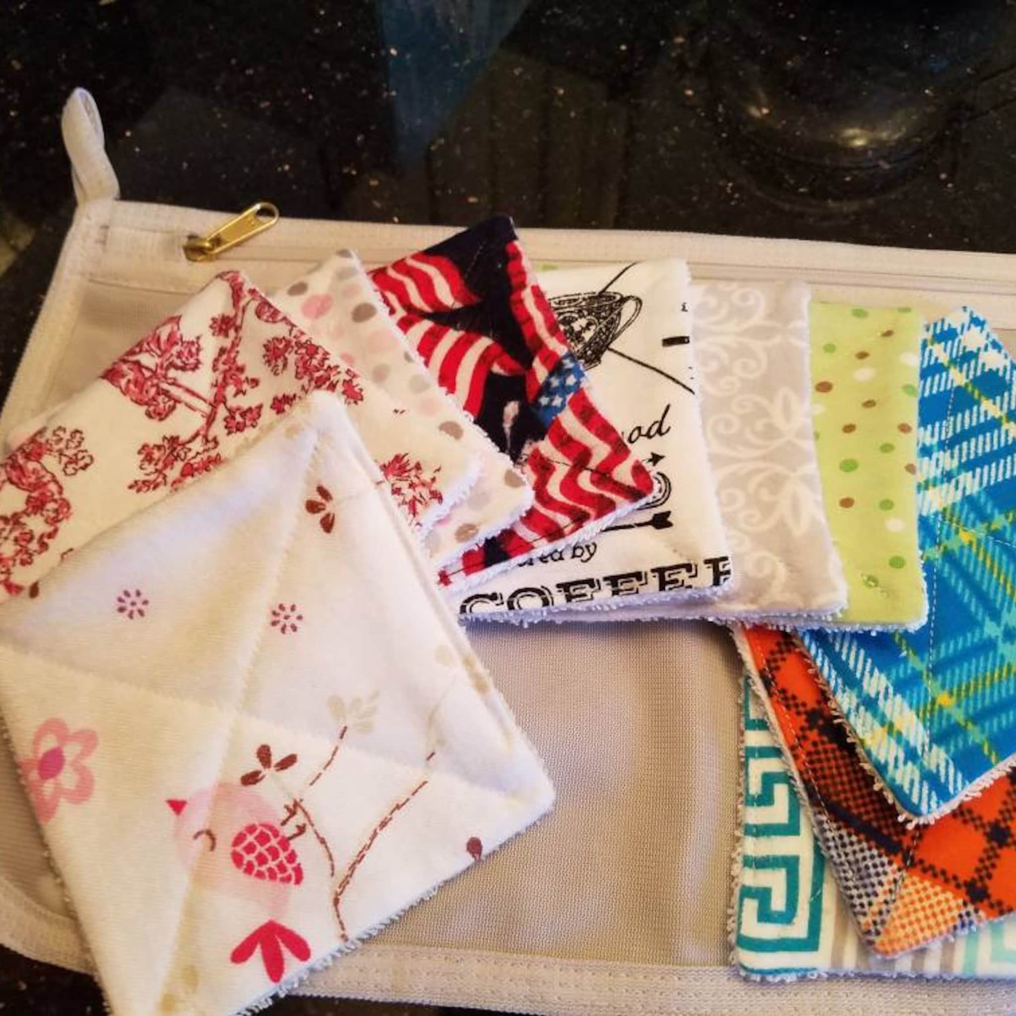 Cloth pot holders with assorted patterns and colors, including floral, plaid, and USA flag designs