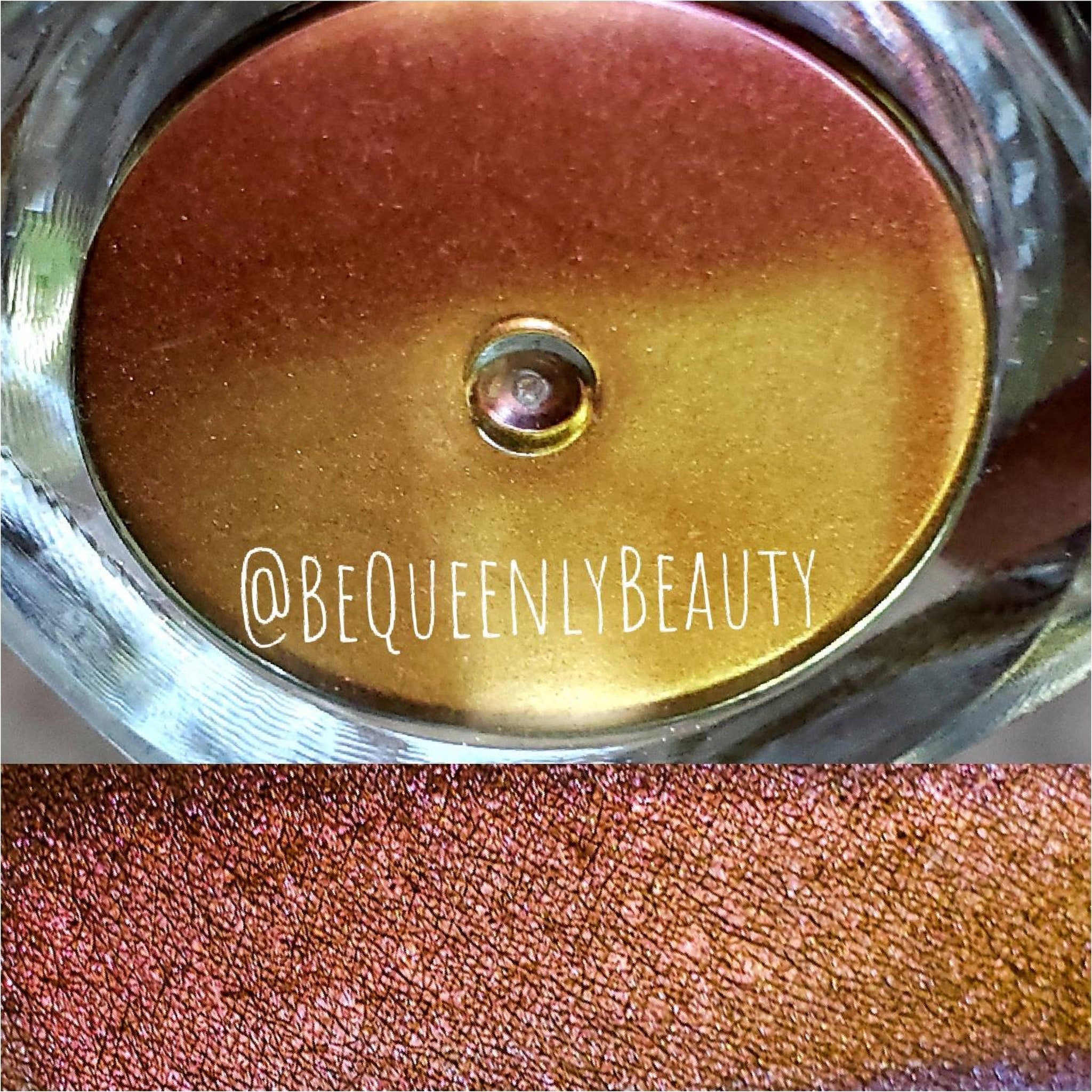 Eyeshadow with metallic gold and copper tones, @BEQUEENLYBEAUTY text visible, in a glass container