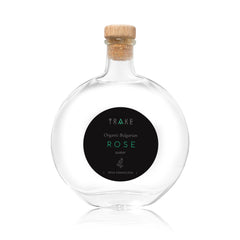 Rose water bottle with clear glass, cork stopper, and black label with text