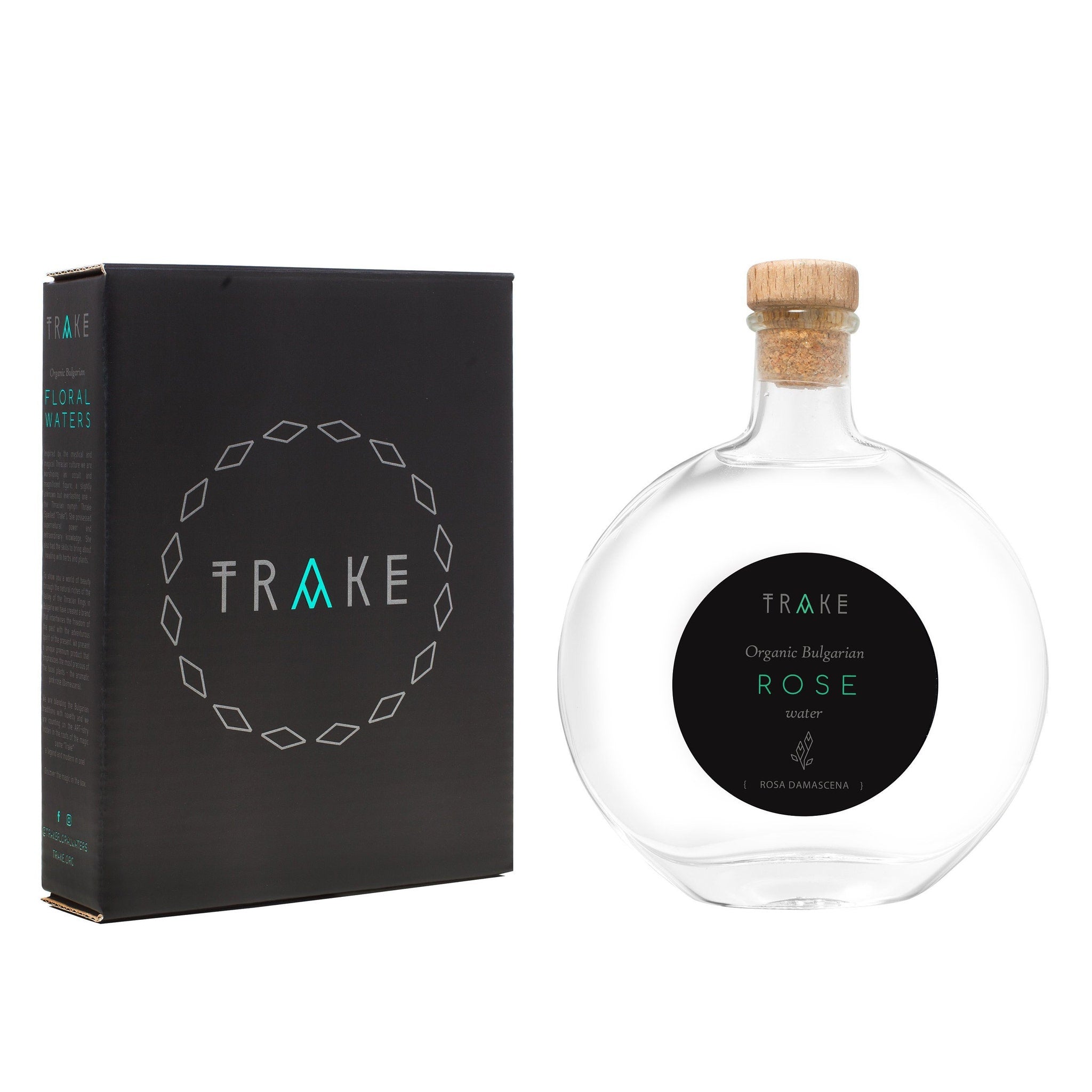 Rose water bottle with clear glass, wooden cork, and black label with TRAKE text
