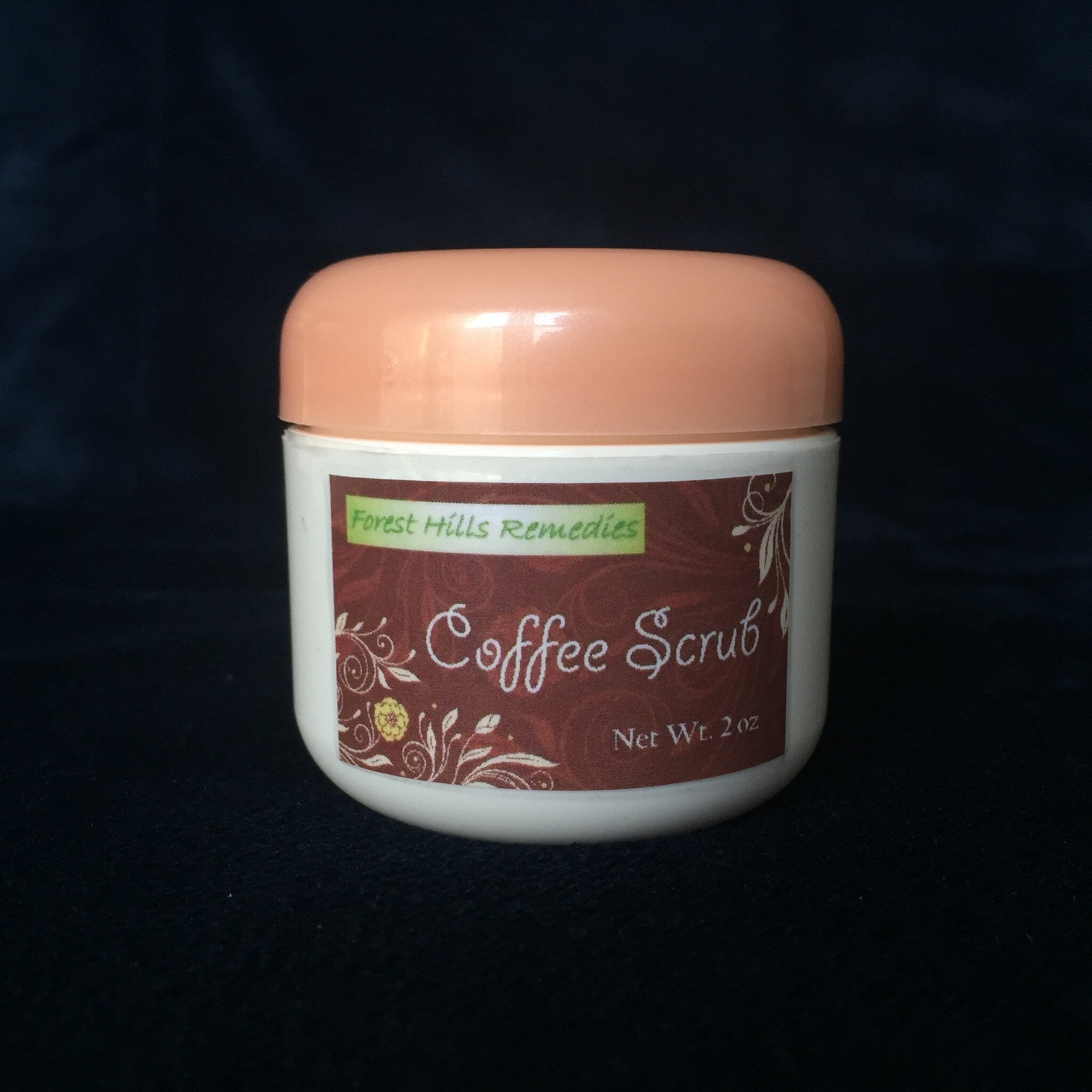 Coffee scrub jar with peach lid, white body, and brown label with floral design, Forest Hills Remedies brand