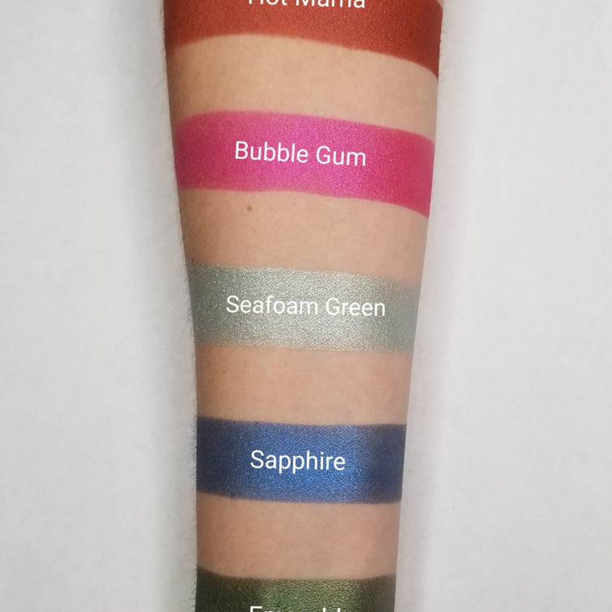 Side view of vegan bubblegum pink pressed eyeshadow showing smooth matte texture in compact palette