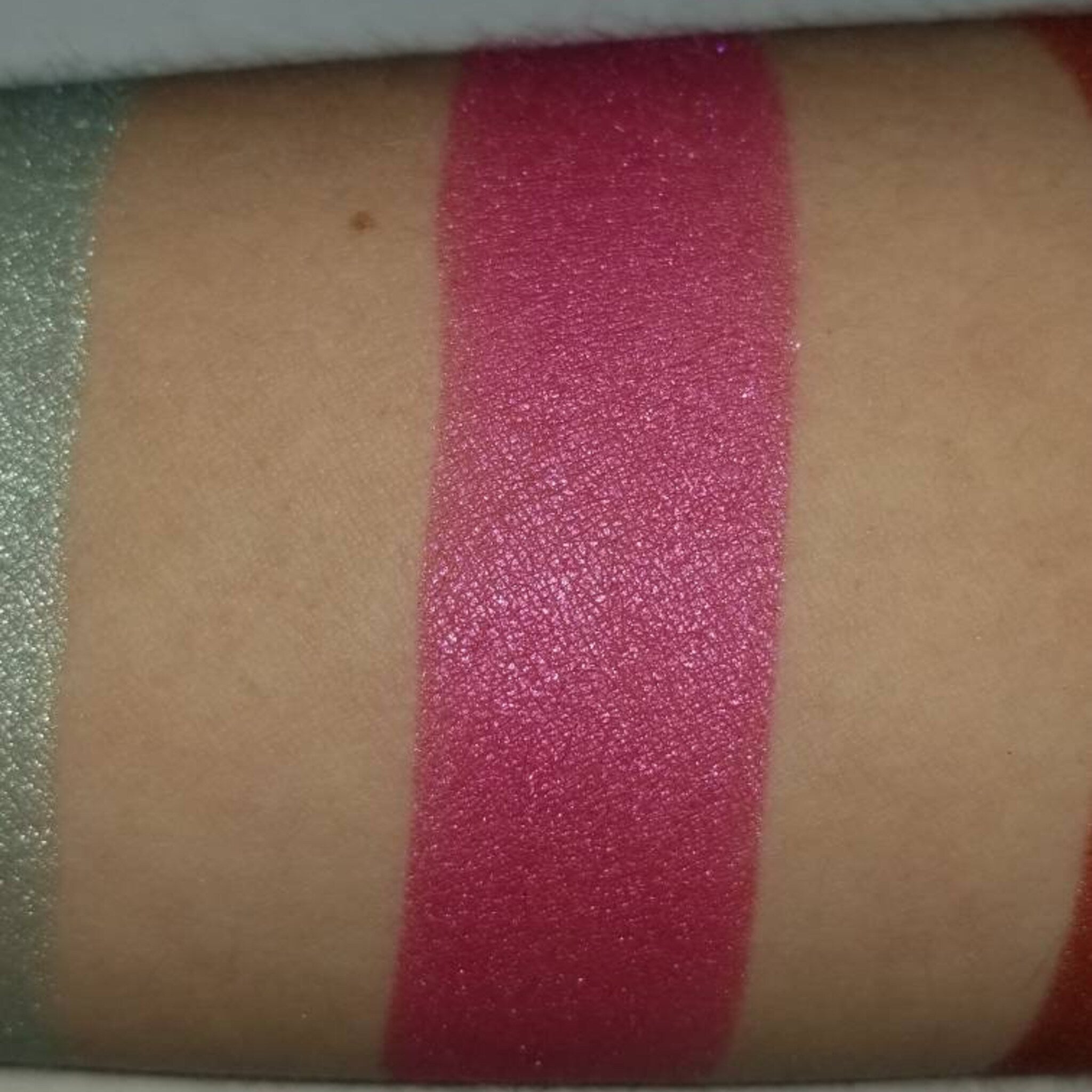 Close-up of vegan bubblegum pink pressed eyeshadow being applied to eyelid with brush