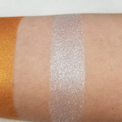 Hand applying silver blue vegan eyeshadow with a brush, showcasing smooth pigment blend on eyelid.
