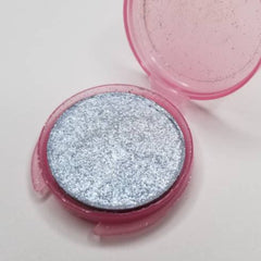 Close-up of vegan silver blue pressed eyeshadow with shimmering metallic finish in compact case