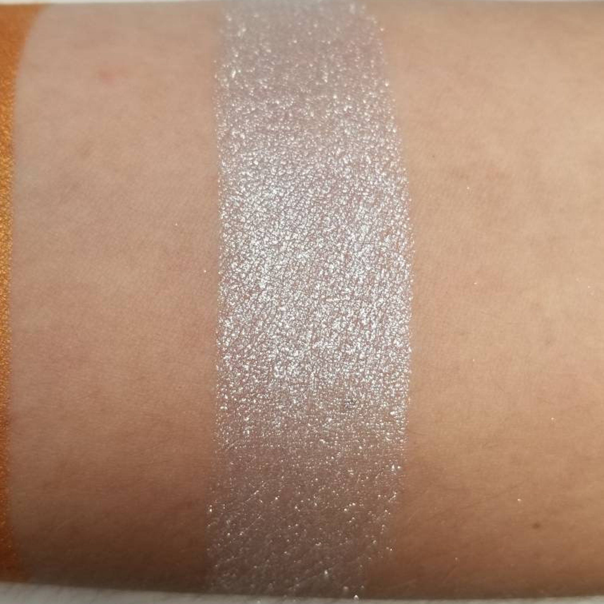 Close-up of silver blue vegan pressed eyeshadow pan showing shimmer texture and smooth finish
