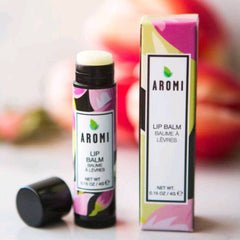 Lip balm with black tube and AROMI label, floral pattern packaging, and open cap