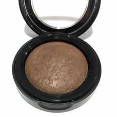 Close-up of baked eyeshadow pan showing rich brindle brown shade with subtle shimmer and smooth texture
