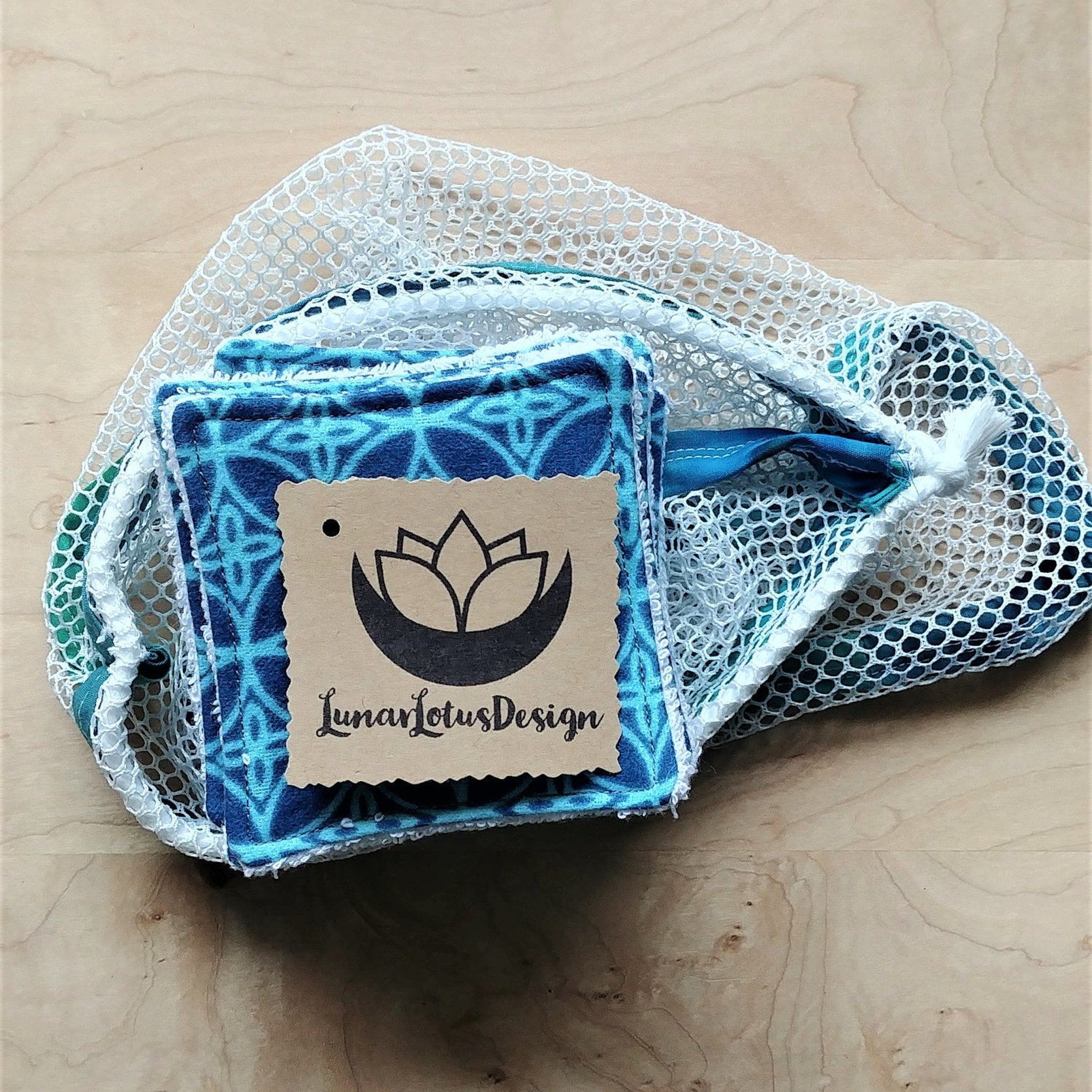 Reusable face pads with blue patterned fabric, white mesh bag, and Lunar Lotus Design tag